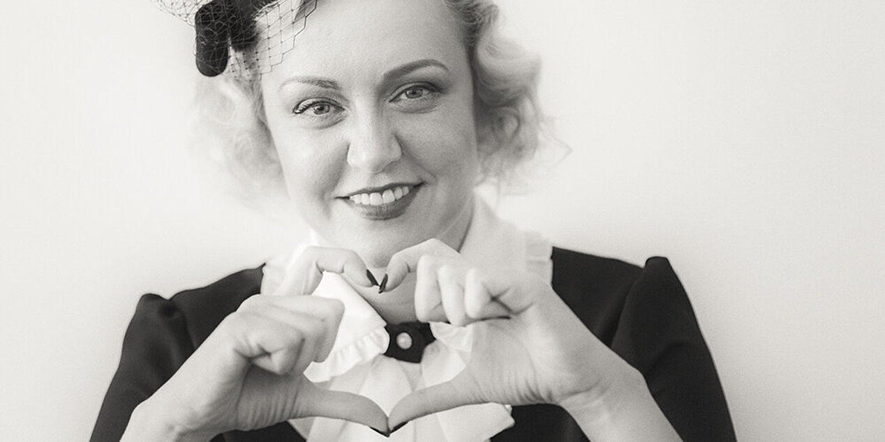 Olga Karatch forms a heart with her fingers.