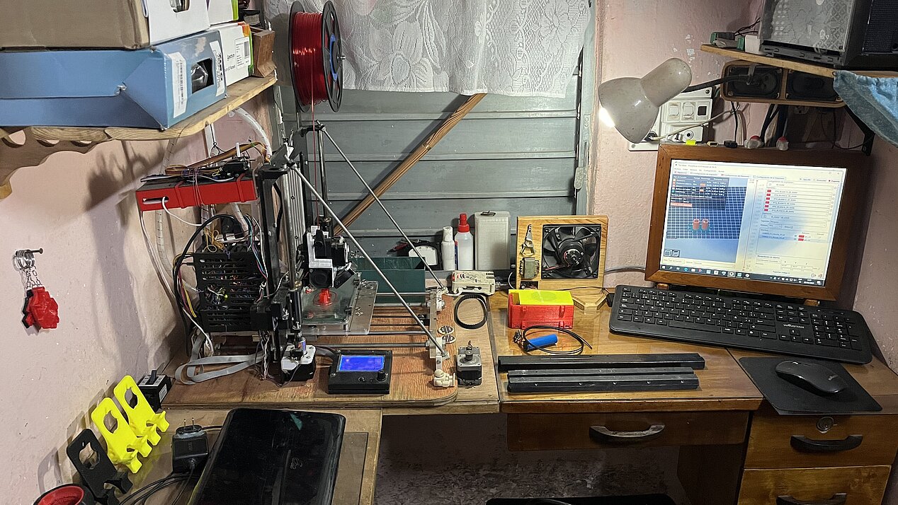 The picture shows a small room with extensive technical equipment. The room seems to be a repair room. In addition to computer, there are also wires, diverse tools and measuring instruments, all neatly stowed away on a small work surface. The photo gives an insight into the activities of the Copincha-Community in Cuba.