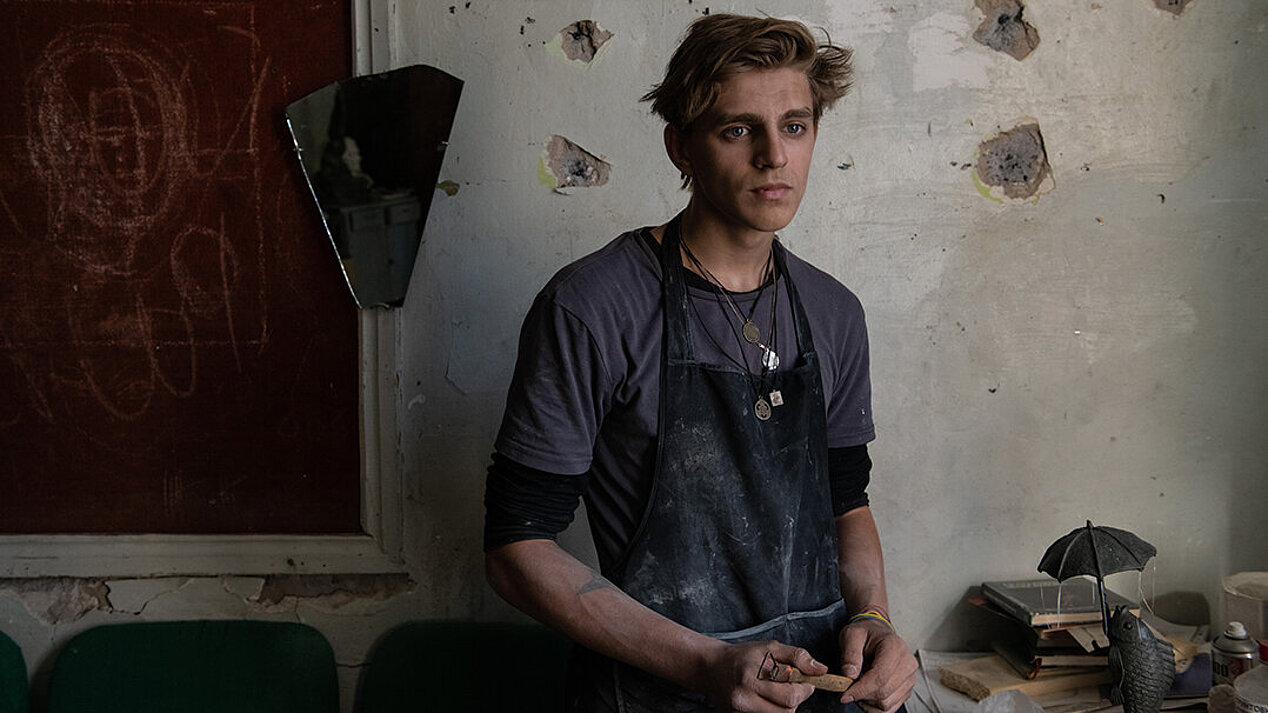 A young man namend Konstantin, 18, is standing in the middle of an empty workshop. He is studying sculpture. The war tore his family apart. Photograph: Ben Shermann