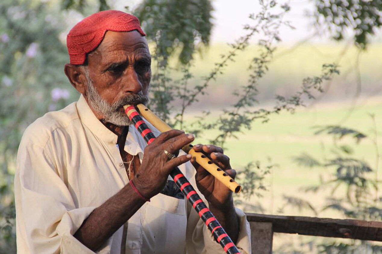 Ein Mann spielt mit zwei Flöten gleichzeitig.